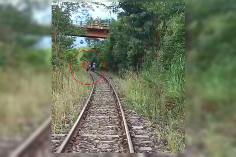 Homem cai de ponte, vai parar nos trilhos e escapa de trem por minutos. Veja vídeo