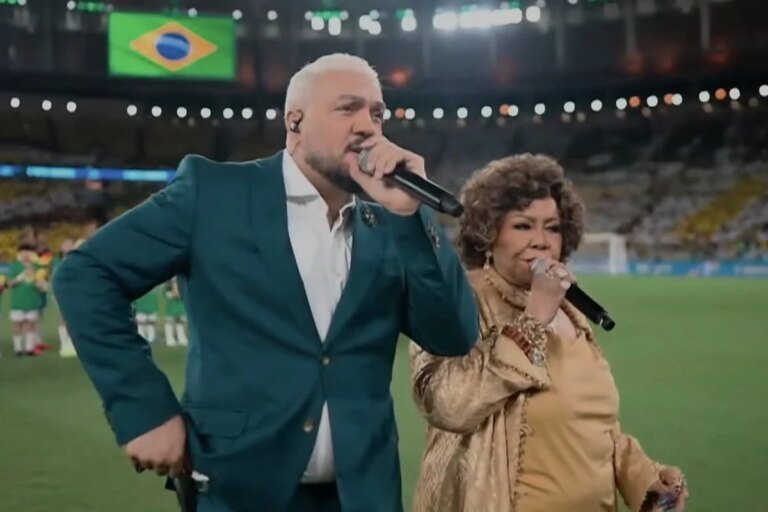 Belo e Alcione são detonados após cantar hino em amistoso da Seleção